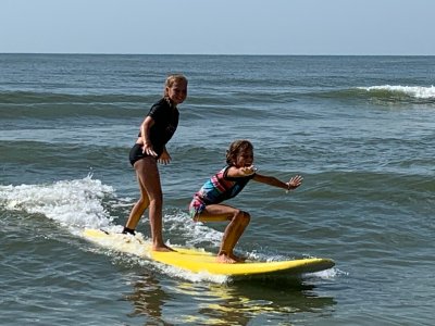 a young girl riding a wave on a surfboard in the water