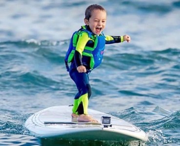 a girl riding a wave on a surf board on a body of water