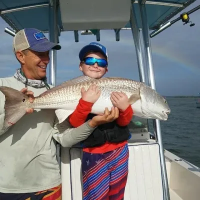 a man holding a fish on a boat