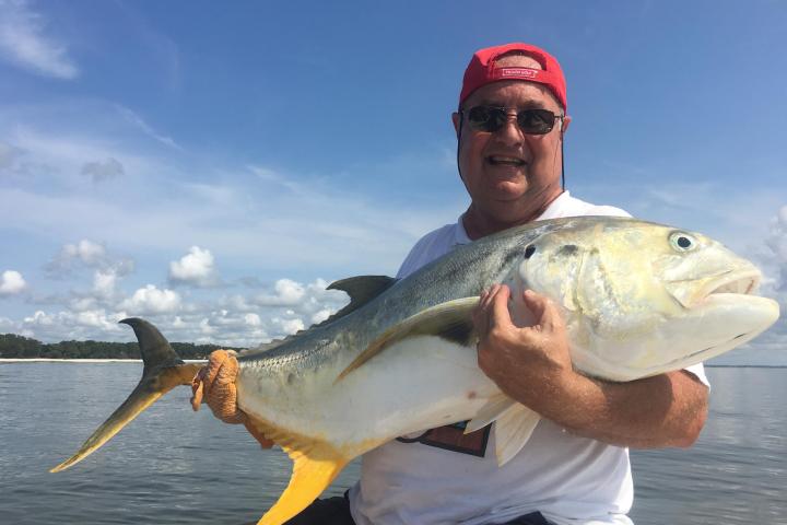 a man holding a fish in the water