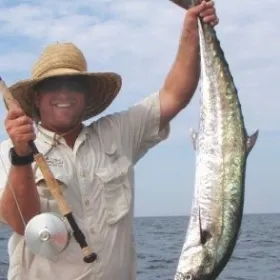 a man holding a fish in the water