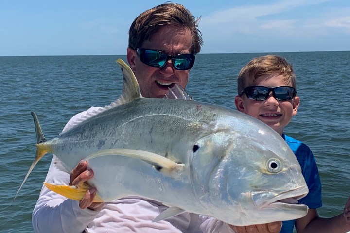 a man holding a fish swimming under water