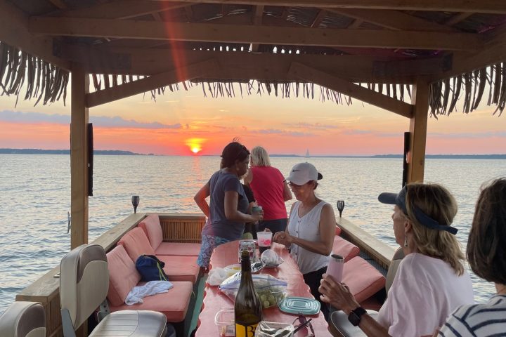 a group of people sitting at a table in front of water