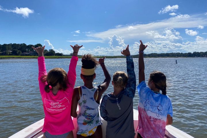 a group of people standing next to a body of water