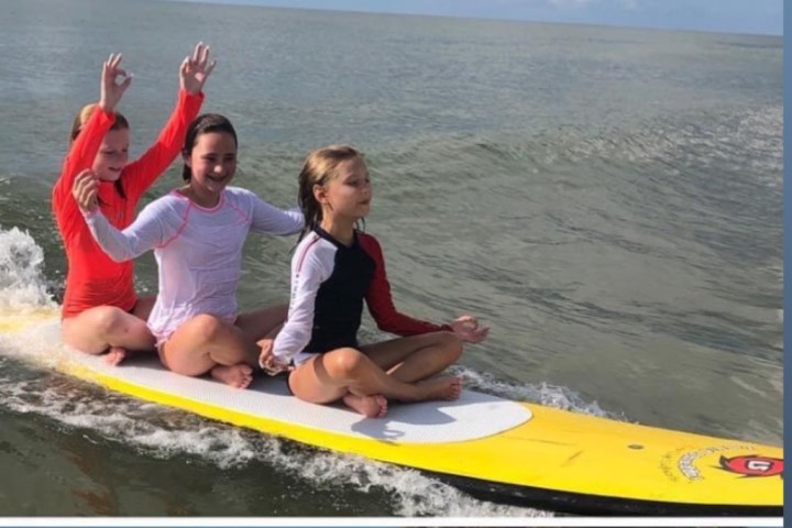 a young girl riding a wave on a surfboard in the water