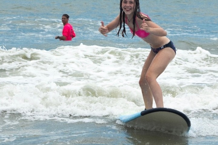 a woman riding a wave on a surfboard in the water