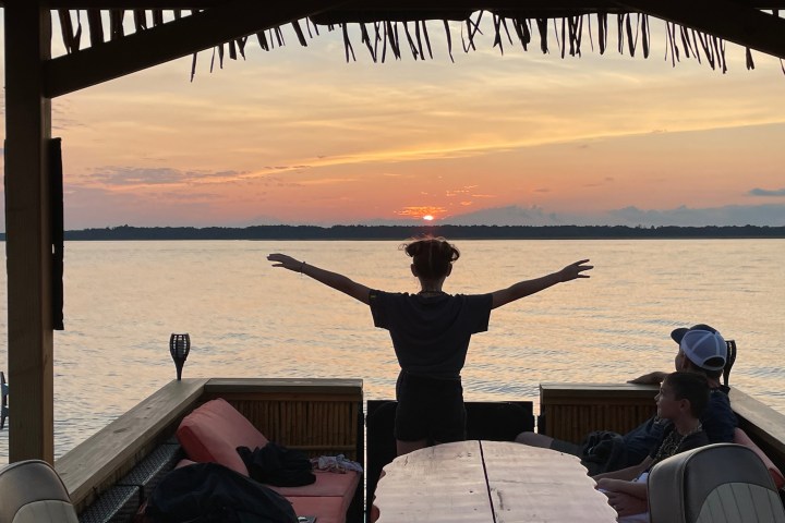 a person sitting on a bench next to a body of water